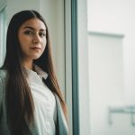 woman in white button up shirt and black coat