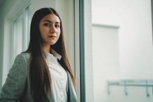 woman in white button up shirt and black coat